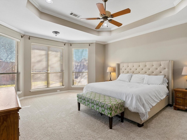 bedroom with carpet floors, multiple windows, and a raised ceiling