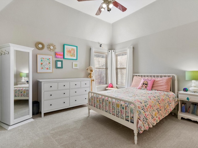 bedroom with vaulted ceiling, a ceiling fan, and light colored carpet