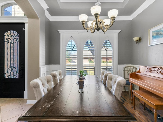 dining area featuring a chandelier, a tray ceiling, wainscoting, and ornamental molding