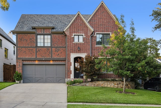 view of front of home featuring a garage, brick siding, driveway, roof with shingles, and a front lawn