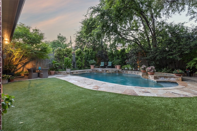 view of swimming pool with a patio, a lawn, a fenced backyard, and a pool with connected hot tub