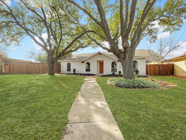 single story home with brick siding, a front lawn, and fence