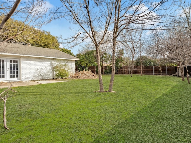 view of yard with french doors and fence