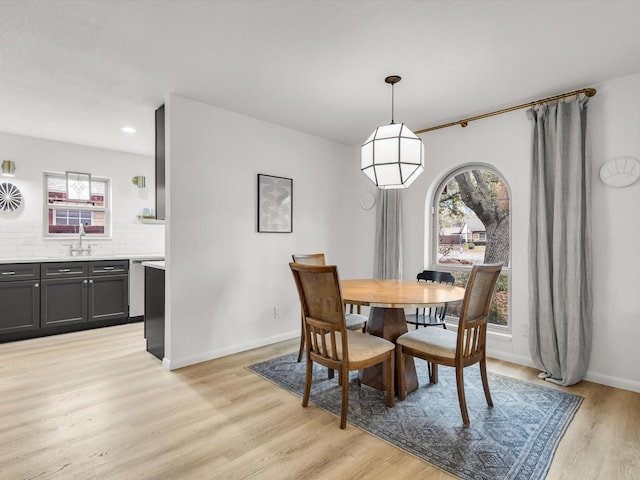 dining area with light wood finished floors, baseboards, and recessed lighting