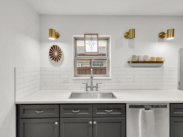 kitchen featuring gray cabinetry, a sink, light countertops, stainless steel dishwasher, and open shelves