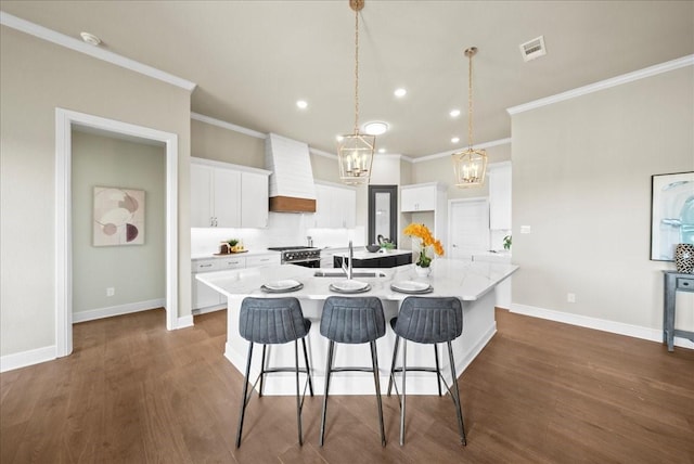 kitchen with a spacious island, dark wood-type flooring, baseboards, custom exhaust hood, and a sink