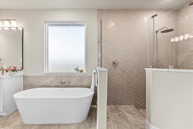 bathroom featuring vanity, tile walls, walk in shower, and a freestanding tub