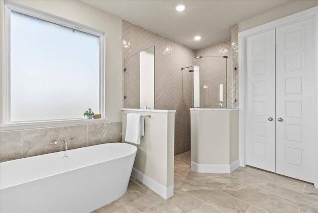 bathroom featuring recessed lighting, a freestanding tub, a closet, and a walk in shower