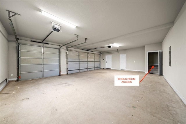 garage featuring a garage door opener and baseboards