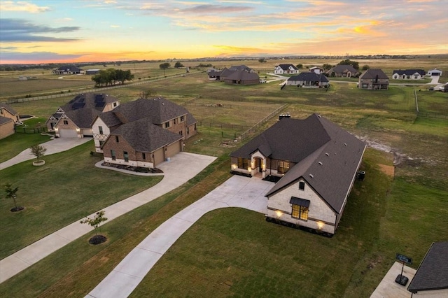 aerial view at dusk with a rural view and a residential view