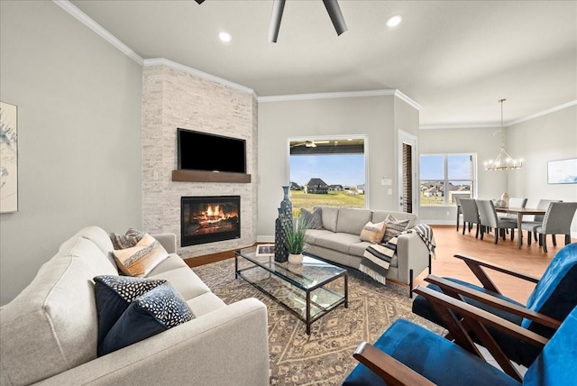 living room featuring wood finished floors, an inviting chandelier, a fireplace, recessed lighting, and ornamental molding