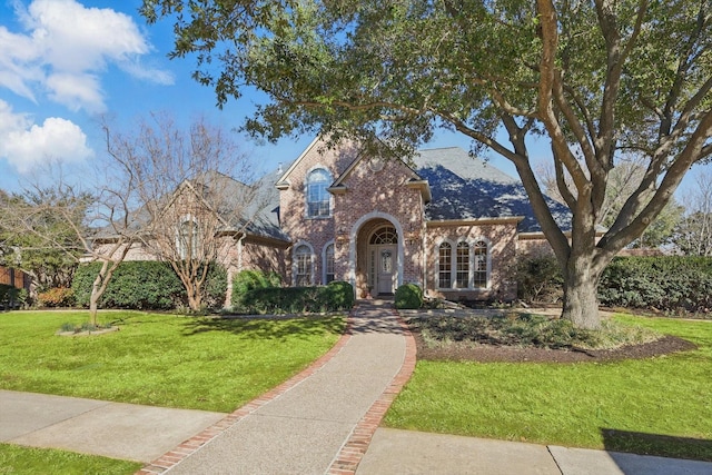 view of front of house with a front lawn and brick siding