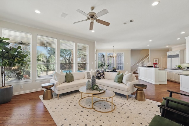 living area with recessed lighting, visible vents, stairway, and wood finished floors