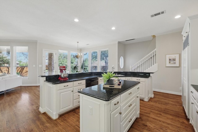 kitchen featuring a healthy amount of sunlight, black dishwasher, dark wood-type flooring, and a center island