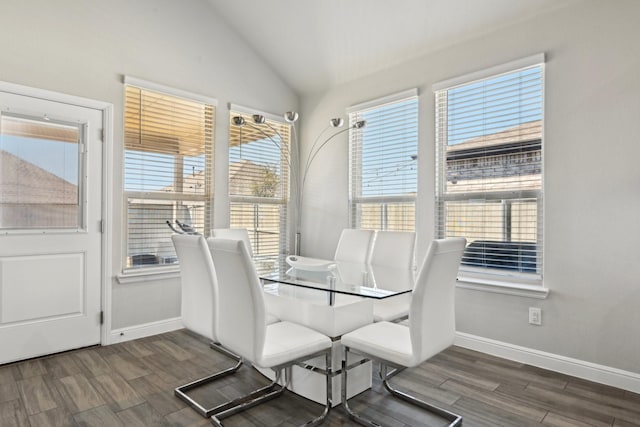 dining space with baseboards, wood finish floors, and vaulted ceiling