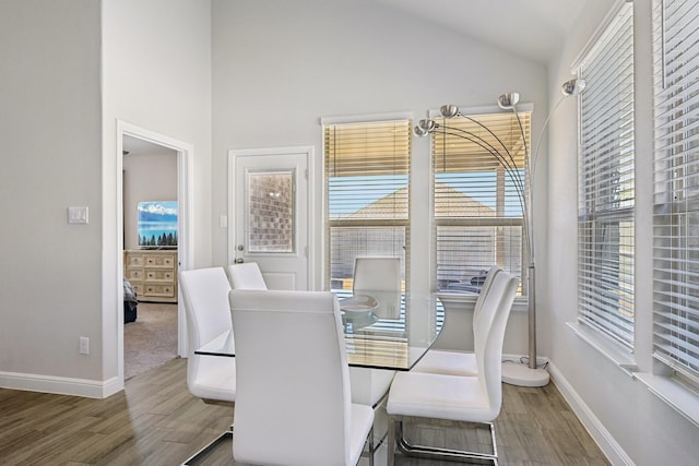 dining room featuring baseboards, lofted ceiling, and wood finished floors