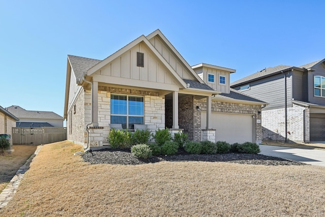 craftsman inspired home with board and batten siding, a shingled roof, driveway, and fence