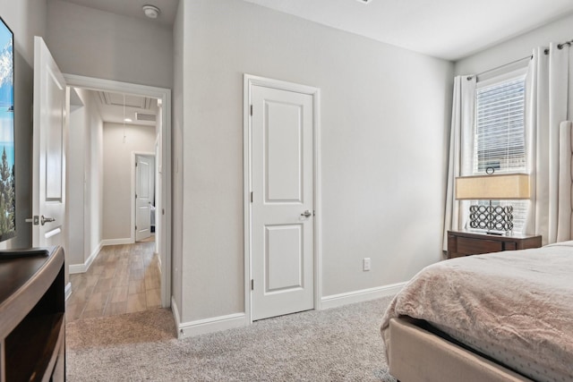 carpeted bedroom with visible vents, attic access, and baseboards