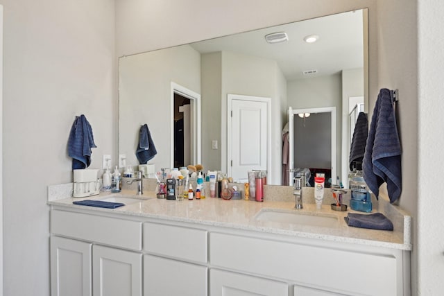 full bathroom with double vanity, visible vents, and a sink