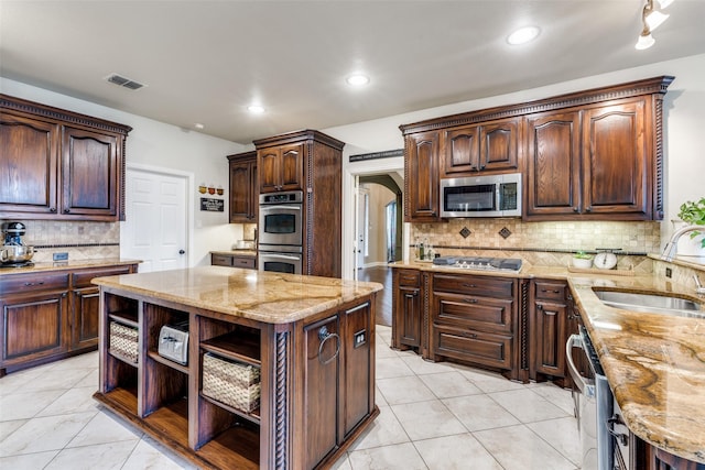 kitchen with visible vents, light stone counters, appliances with stainless steel finishes, open shelves, and a sink