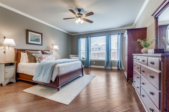 bedroom with baseboards, ceiling fan, wood finished floors, and crown molding