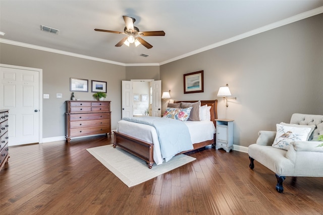 bedroom featuring baseboards, visible vents, dark wood finished floors, and crown molding