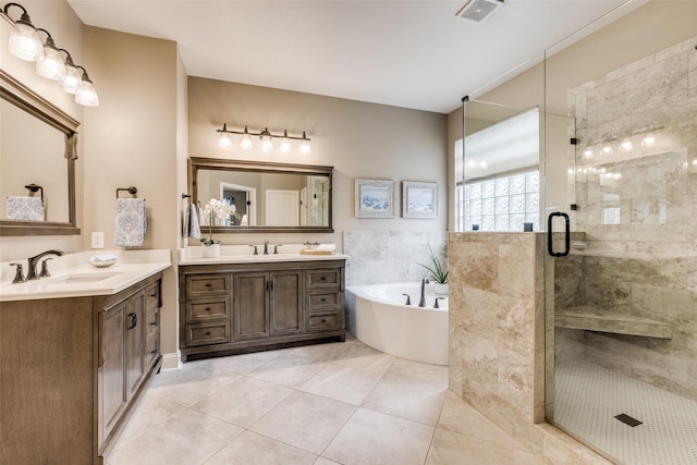 bathroom with a garden tub, a shower stall, visible vents, and a sink