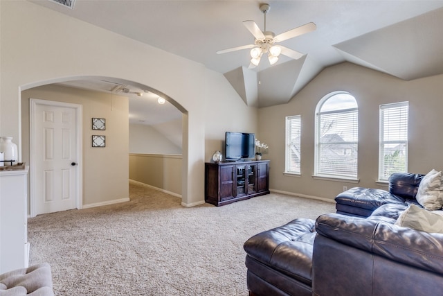 living room with arched walkways, carpet, lofted ceiling, a ceiling fan, and baseboards