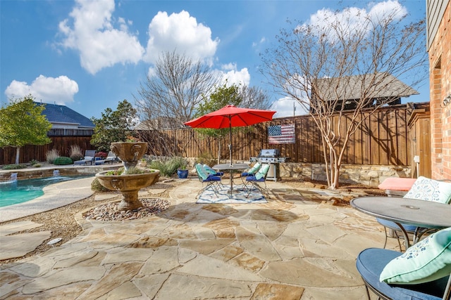 view of patio / terrace with outdoor dining area, area for grilling, a fenced backyard, and a fenced in pool