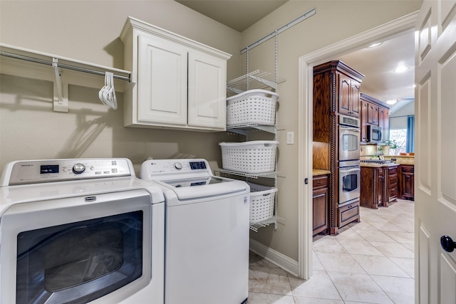 laundry room with baseboards, cabinet space, and washing machine and clothes dryer