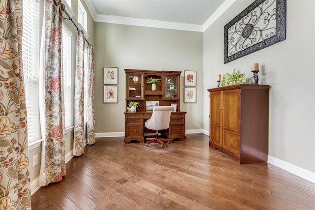 office area featuring baseboards, light wood-type flooring, and crown molding