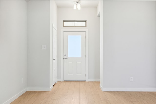 foyer featuring light wood-style flooring and baseboards