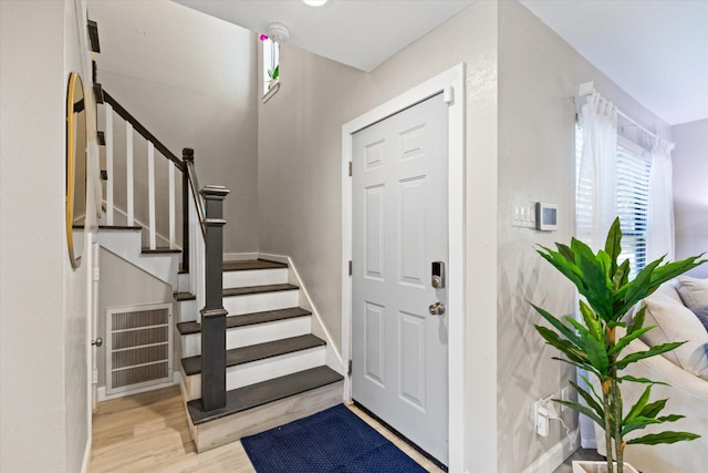 entrance foyer featuring stairs and wood finished floors