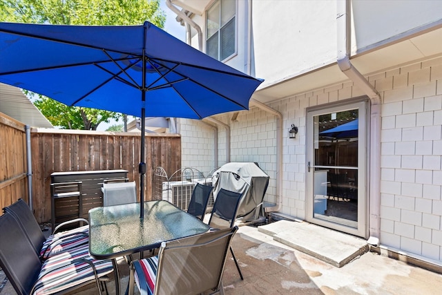 view of patio with outdoor dining area, grilling area, and fence