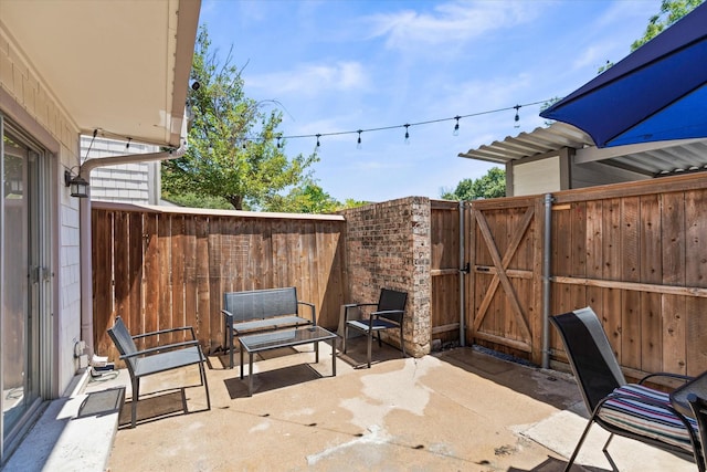 view of patio with a gate and fence