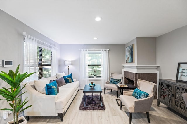 living area with a healthy amount of sunlight, a fireplace, wood finished floors, and recessed lighting