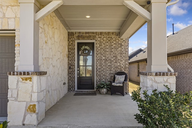 view of exterior entry with stone siding and brick siding