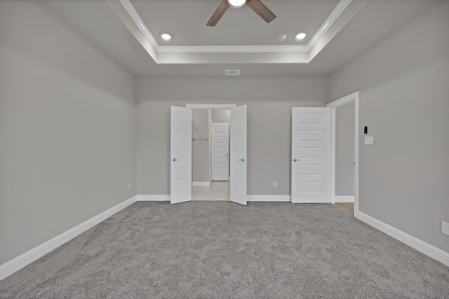 unfurnished bedroom featuring ornamental molding, a raised ceiling, and visible vents