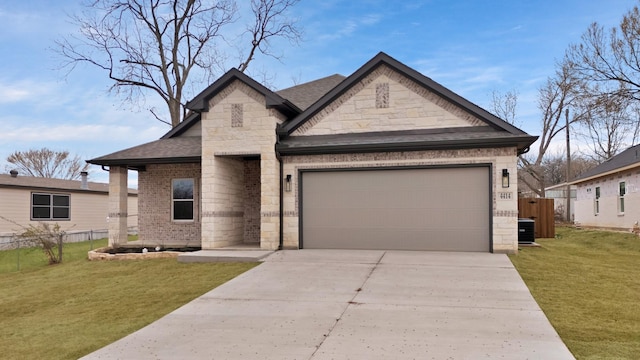 view of front facade with a garage, a front yard, brick siding, and fence