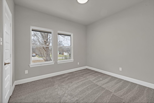 carpeted spare room featuring baseboards