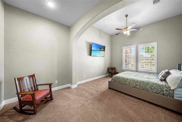 bedroom featuring baseboards, visible vents, a ceiling fan, arched walkways, and carpet flooring