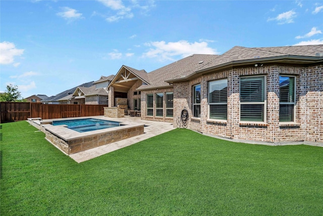 back of property featuring a yard, brick siding, a fenced backyard, and an in ground hot tub