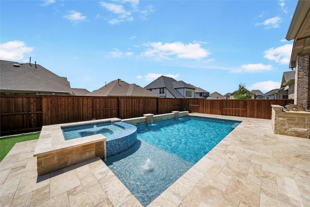 view of pool featuring a pool with connected hot tub, an outdoor kitchen, a patio area, a residential view, and a fenced backyard