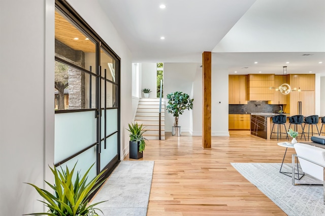 interior space with recessed lighting, baseboards, light wood finished floors, and stairs