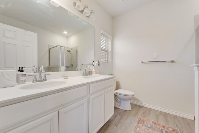 full bathroom with toilet, wood finished floors, a sink, and a stall shower