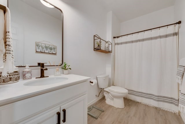 bathroom with toilet, a shower with shower curtain, vanity, and wood finished floors