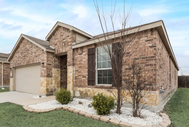 view of front of property with a garage, brick siding, fence, concrete driveway, and stone siding