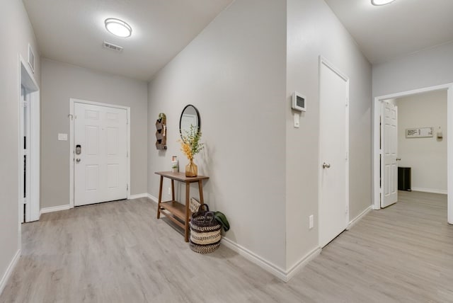 foyer entrance with baseboards, visible vents, and light wood-type flooring