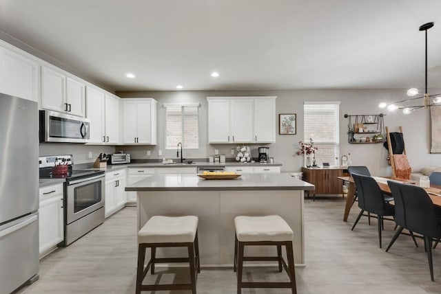 kitchen with a healthy amount of sunlight, a kitchen breakfast bar, stainless steel appliances, and a sink
