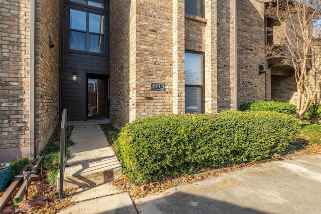 doorway to property featuring brick siding